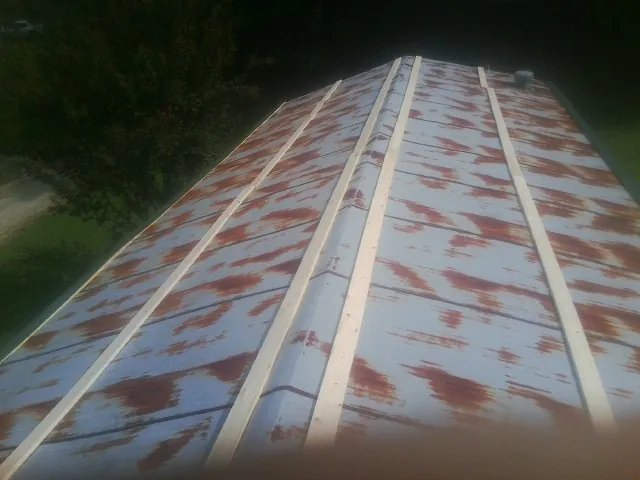 Rusted metal roof panels with new wood purlins before replacement — Storm Damage Roof Repair in Swink by Roofing Brothers