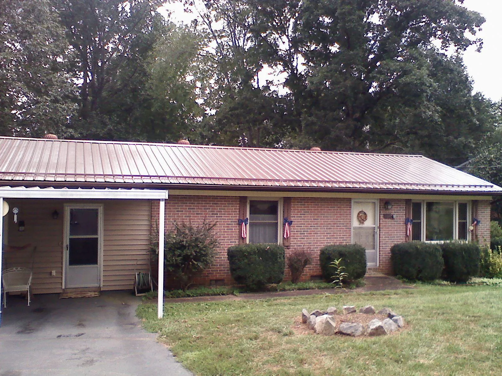 Bronze metal roof and carport on a brick ranch home in Swink